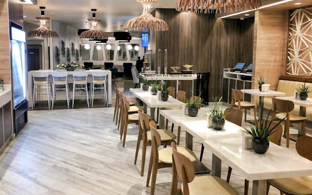Dining area at MERA Business Lounge, Cancun International Airport, featuring modern seating and decor.