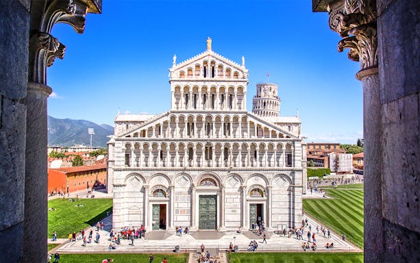 Primate Metropolitan Cathedral of Santa Maria Assunta in Pisa with tourists in the foreground.