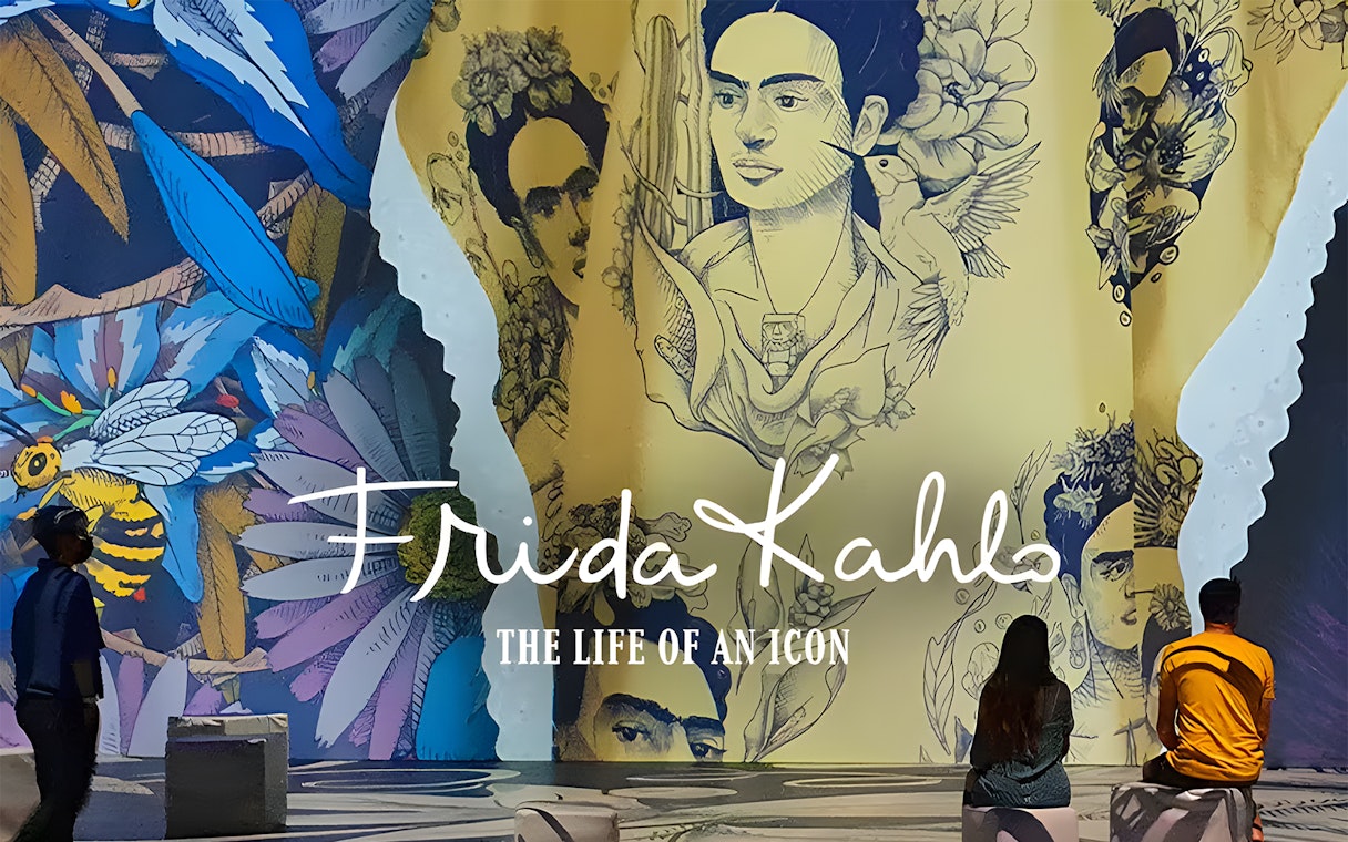 Frida Kahlo exhibit at Art Science Museum's Future World, featuring vibrant murals and visitors.