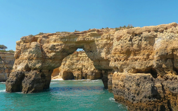 Benagil Caves rock formations with turquoise ocean in Algarve, Portugal.