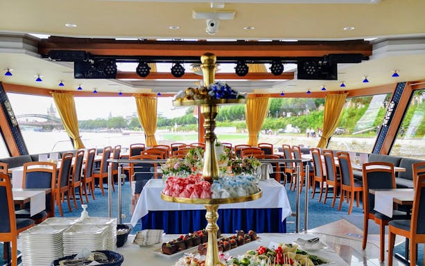 Panorama Lounge Cruise interior with dining setup and river view, Cologne.