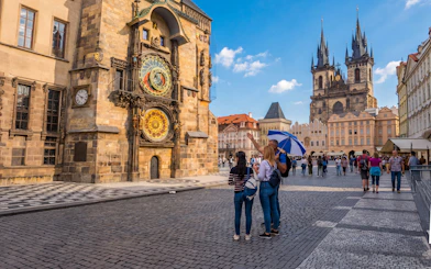 Prague Astronomical Clock with tourists on a guided tour in Old Town Square.