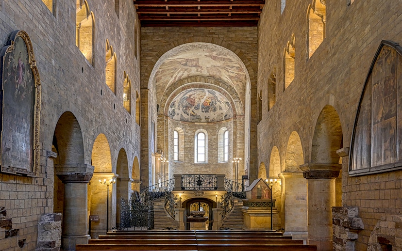 Interior of St. George's Basilica, Prague Castle, with arched ceilings and frescoes.