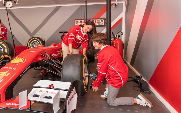 Visitors changing a tire on a Formula 1 car at Ferrari Land.