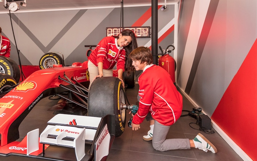 Visitors changing a tire on a Formula 1 car at Ferrari Land.