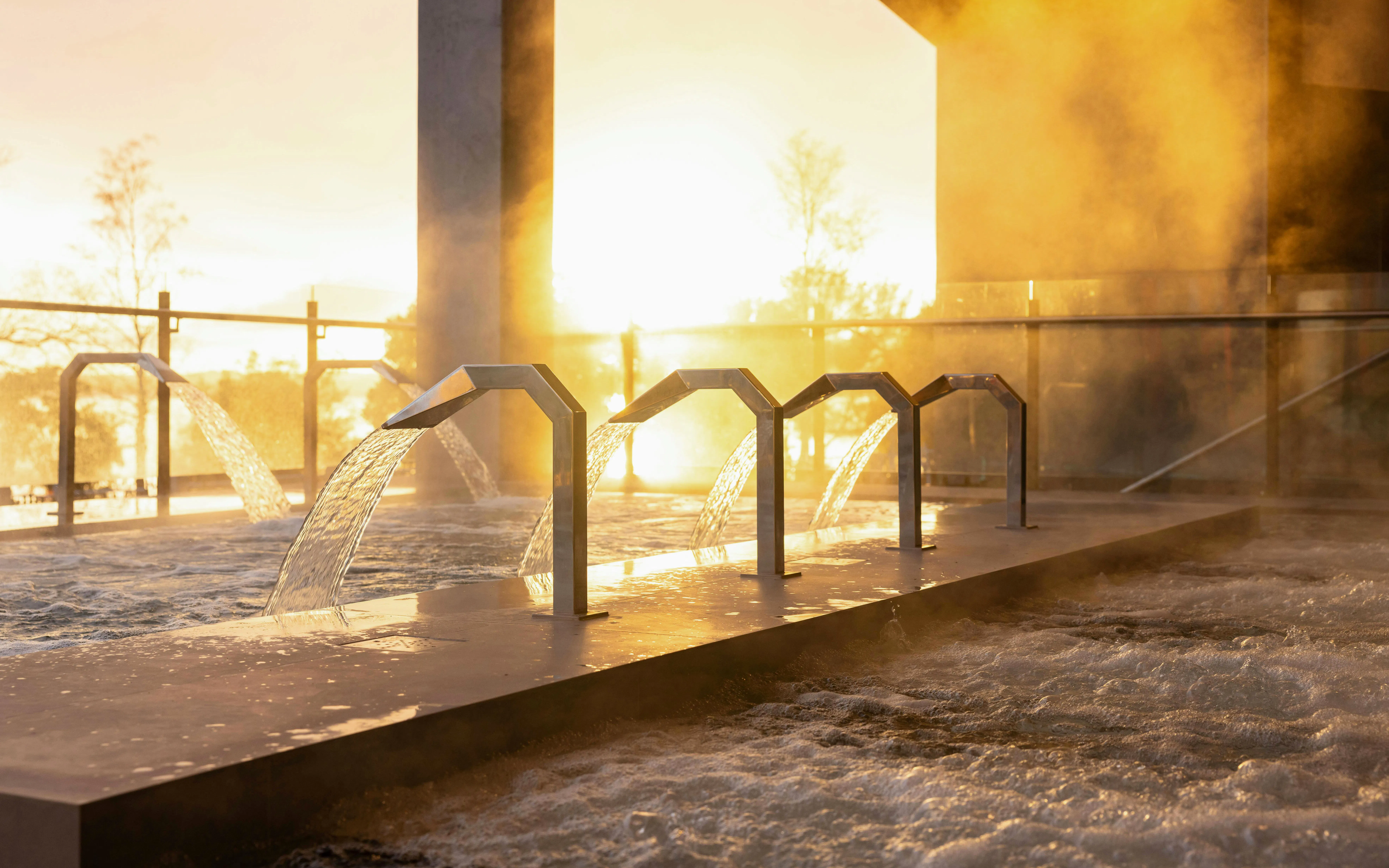 Hydropool with cascading water at Wai Ariki Hot Springs & Spa, Rotorua during sunset.