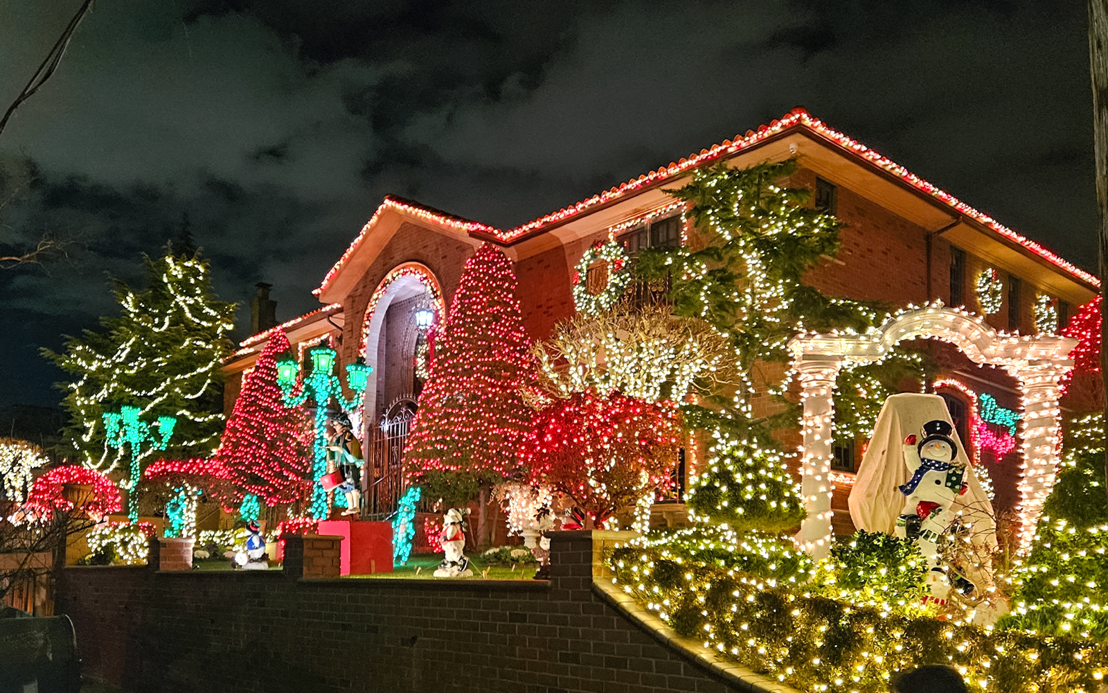 New York house adorned with colorful Christmas lights during holiday bus tour.