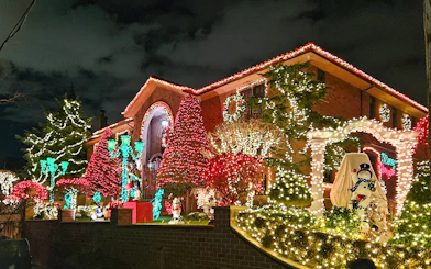 New York house adorned with colorful Christmas lights during holiday bus tour.