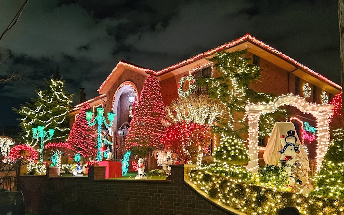 New York house adorned with colorful Christmas lights during holiday bus tour.