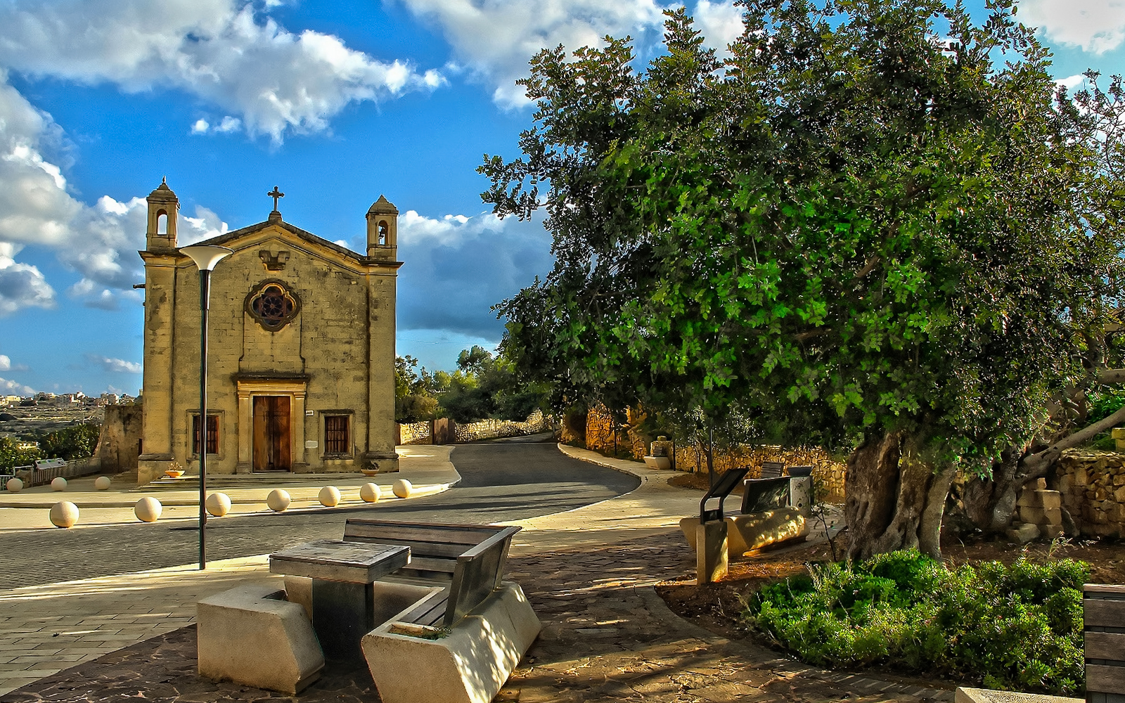 Historic church and tree in Qrendi village, Malta, part of the Marsaxlokk and Blue Grotto tour.