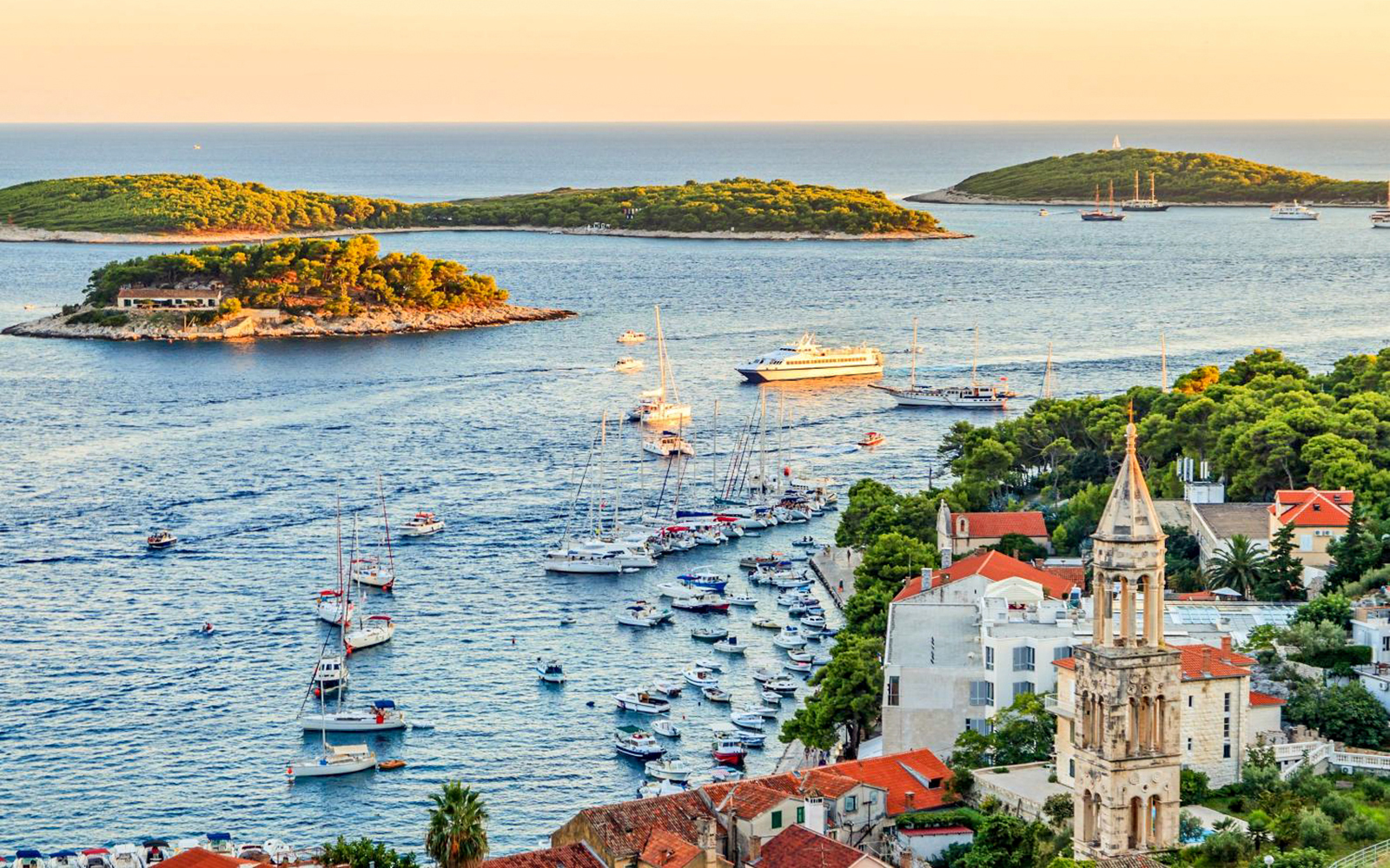 Boats in Hvar harbor with nearby islands, seen during a Trogir full-day cruise.