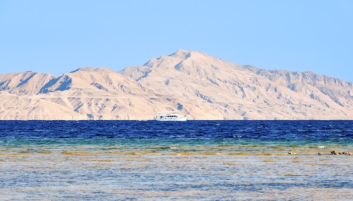 Boat on the Red Sea with Tiran Island mountains in the background, Ras Mohammed National Park.
