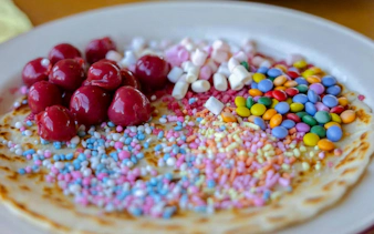 Dutch pancake with cherries, marshmallows, and colorful sprinkles on Amsterdam cruise.