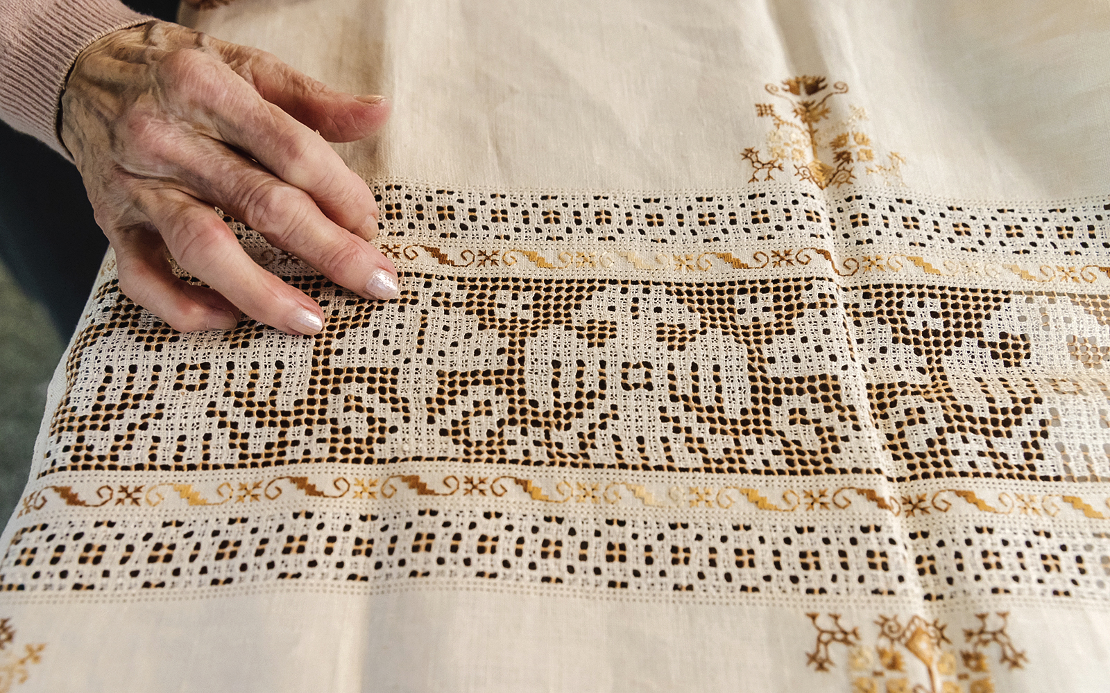 Hand touching intricate lacework at Poble Espanyol, Barcelona.