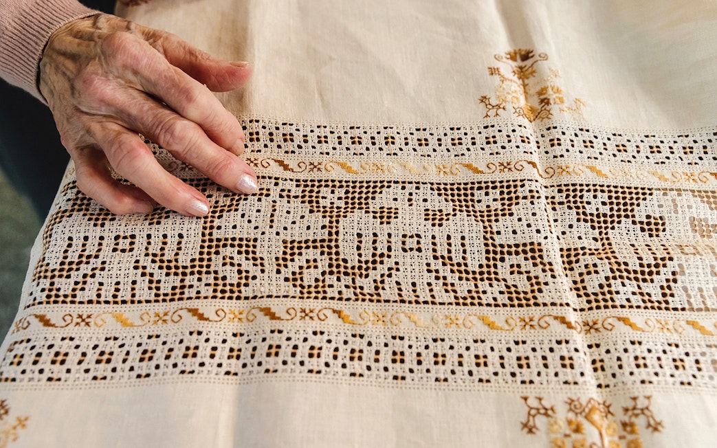 Hand touching intricate lacework at Poble Espanyol, Barcelona.