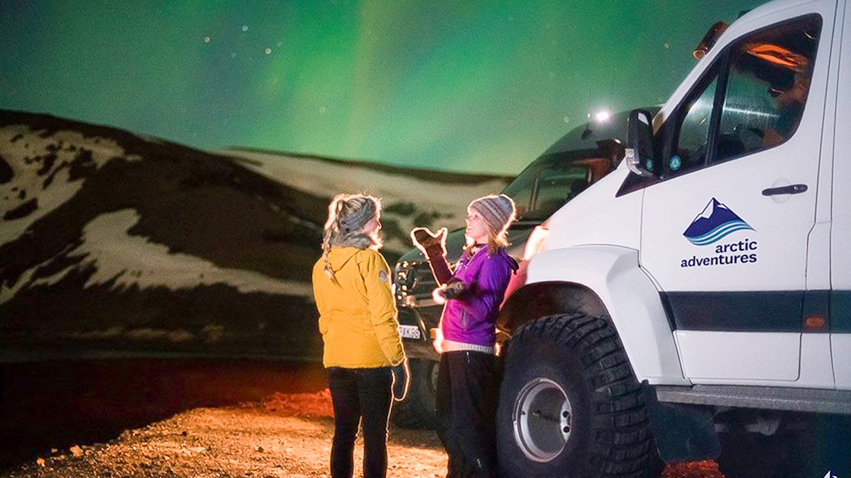 Guests viewing northern lights beside a Super Jeep on Premium Northern Lights Tour.