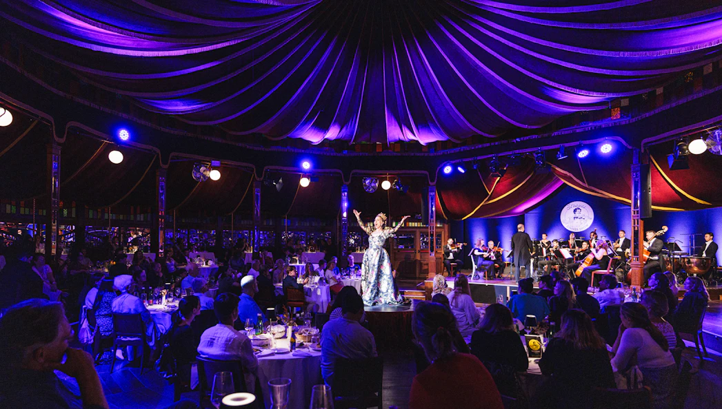 Strauss concert at Prater Vienna with audience dining under a tented ceiling.