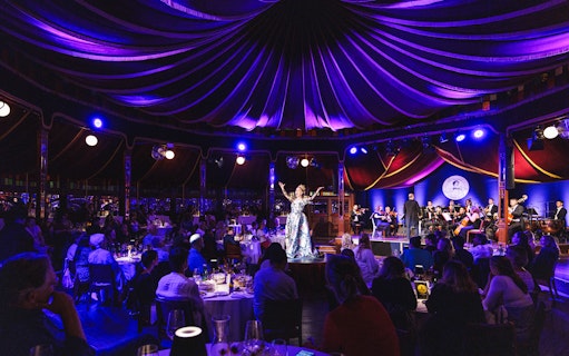 Strauss concert at Prater Vienna with audience dining under a tented ceiling.