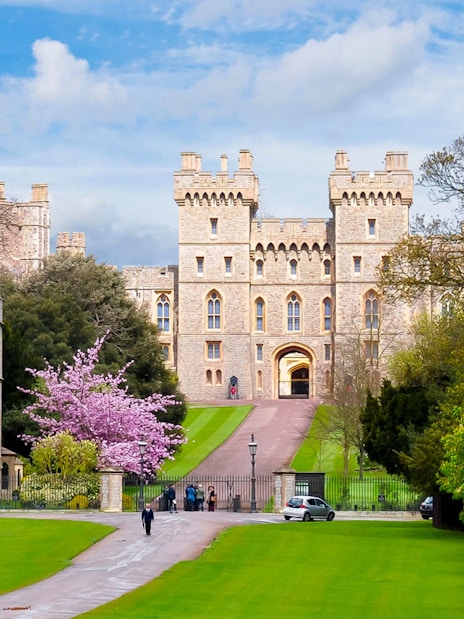 Windsor Castle entrance with lush gardens, part of London to Windsor Castle tours.