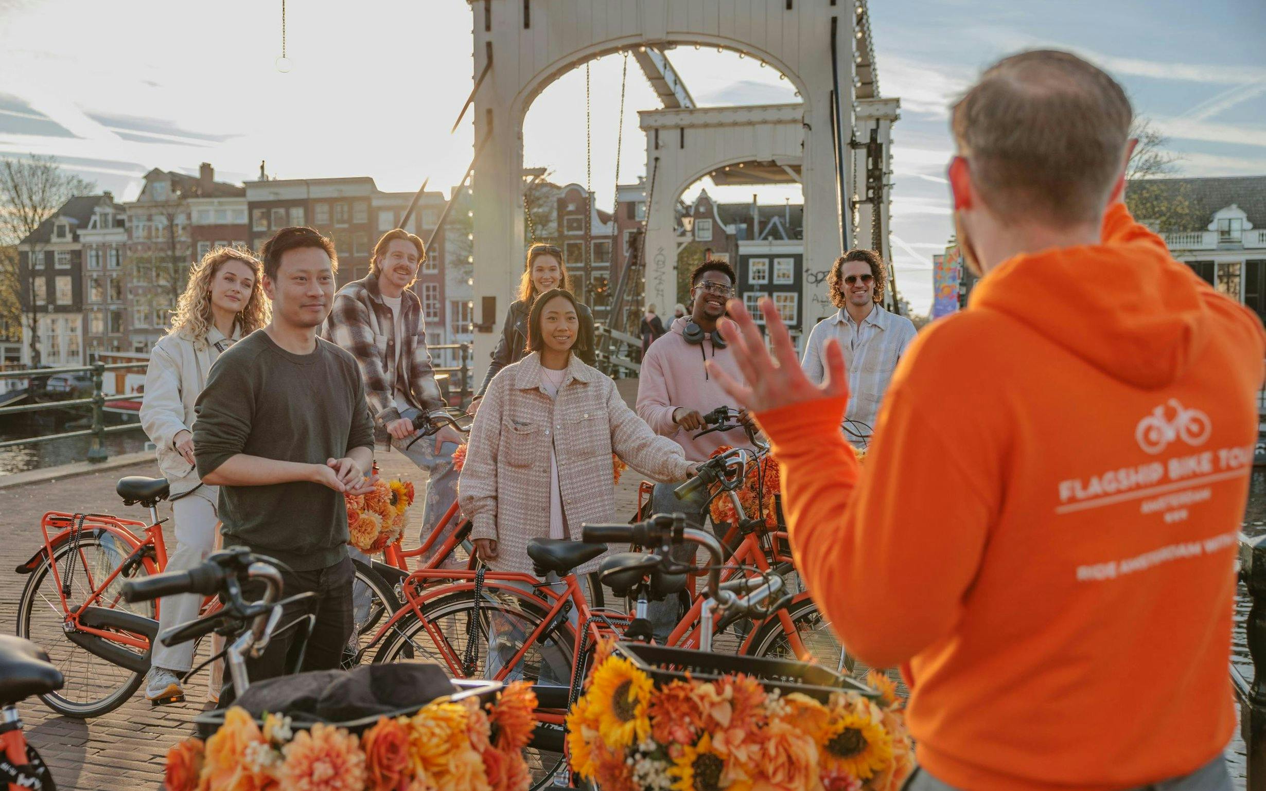 Group on a city bike tour near a bridge in Amsterdam.