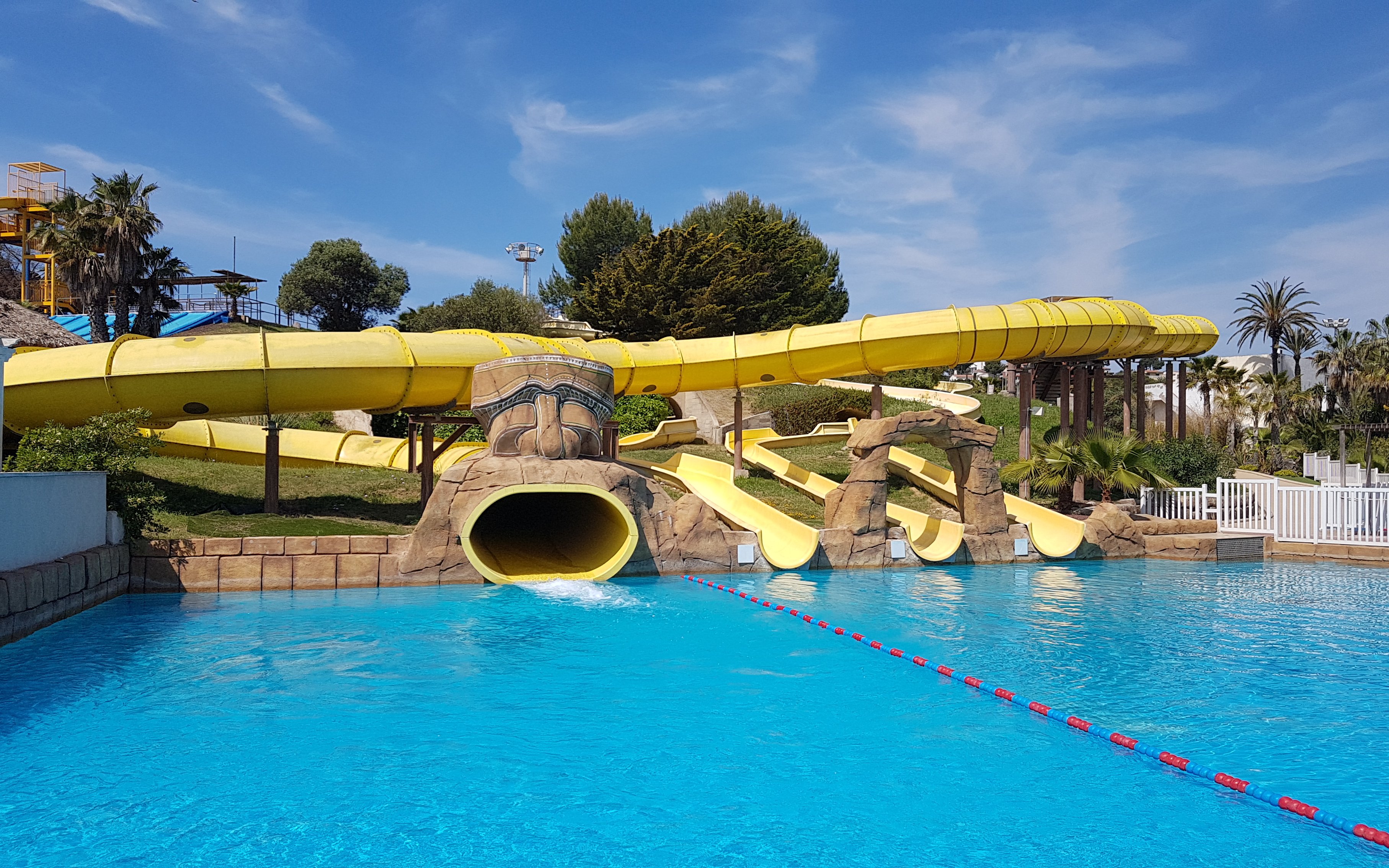 Water slides at Aquopolis Costa Daurada in Tarragona, featuring a large yellow tube slide.