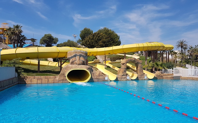 Water slides at Aquopolis Costa Daurada in Tarragona, featuring a large yellow tube slide.