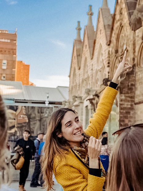 Guide leading a tour group at Sagrada Familia, pointing at architectural details.