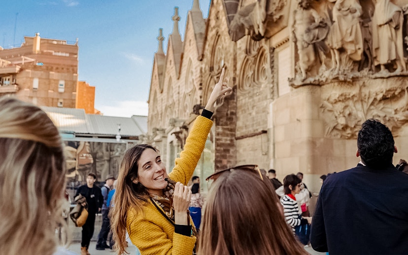 Guide leading a tour group at Sagrada Familia, pointing at architectural details.