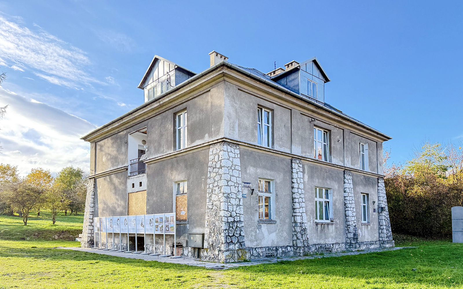 Historic building at Płaszów Concentration Camp site, Kraków, surrounded by greenery.