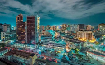 Dar es Salaam cityscape at night with illuminated buildings and streets.