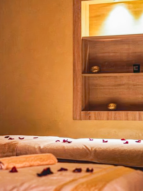 Spa treatment room with massage tables and rose petals, part of Traditional Treatment Hammam & Spa.