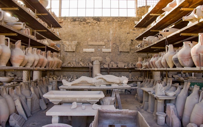 Ancient artifacts and plaster cast in Pompeii storage room.