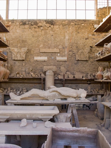 Ancient artifacts and plaster cast in Pompeii storage room.