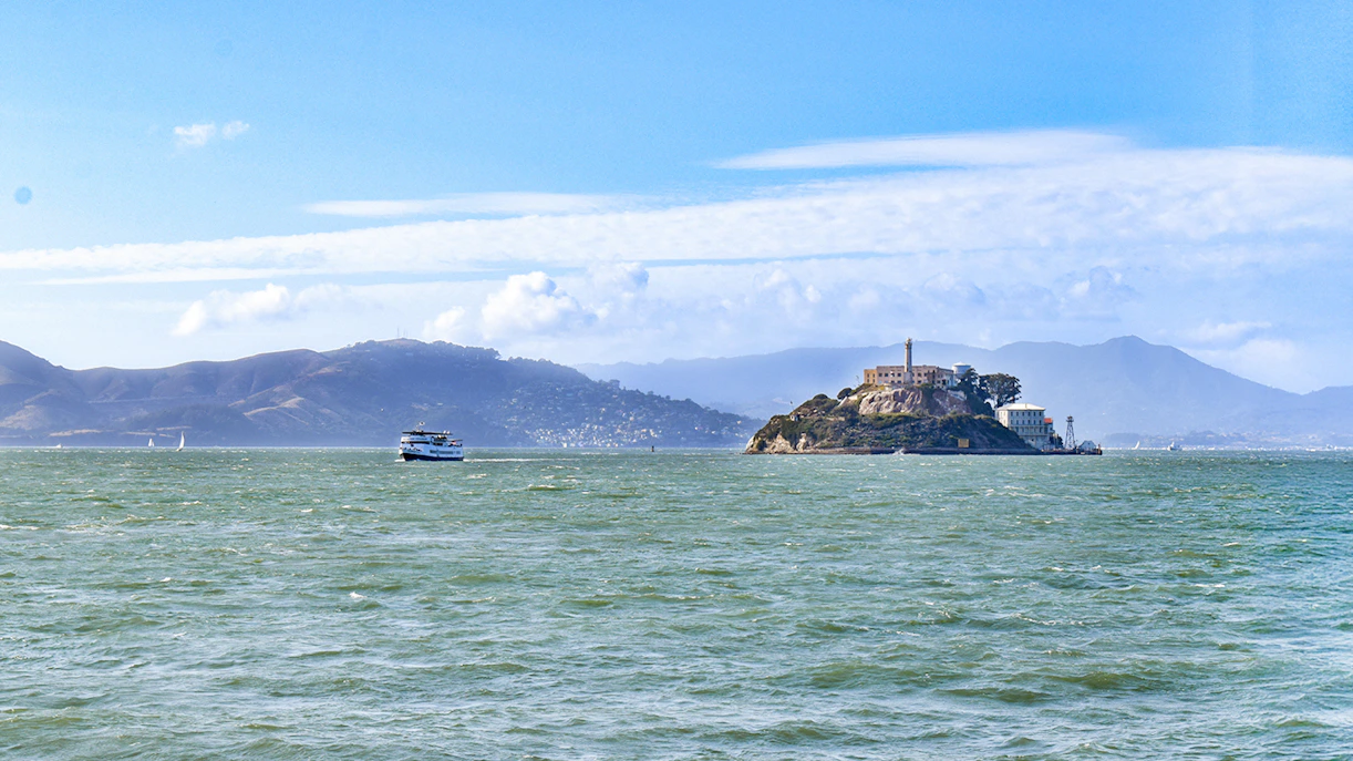 Ferry departing Alcatraz Island, San Francisco Bay, with distant hills.