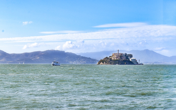 Ferry departing Alcatraz Island, San Francisco Bay, with distant hills.