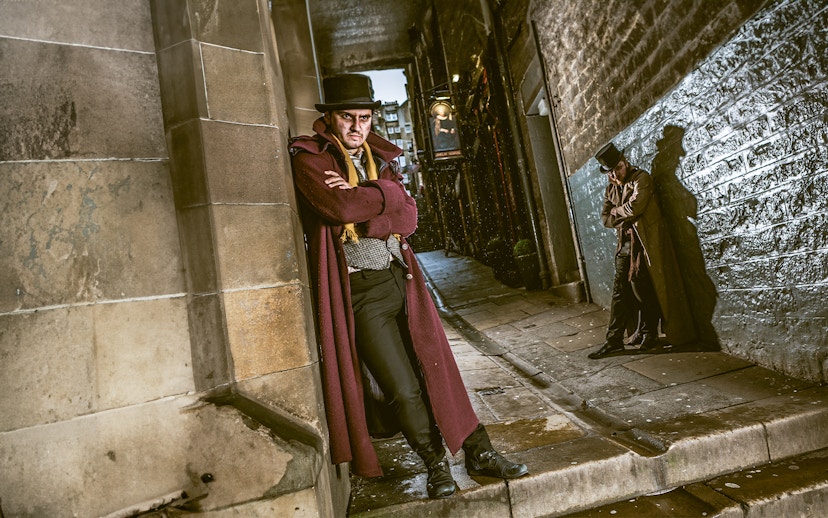 Victorian characters in a dimly lit alley at Edinburgh Dungeon.