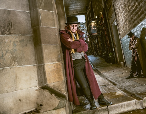 Victorian characters in a dimly lit alley at Edinburgh Dungeon.