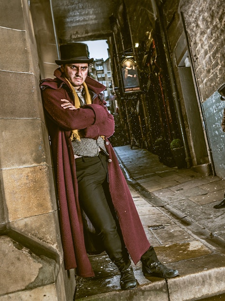 Victorian characters in a dimly lit alley at Edinburgh Dungeon.