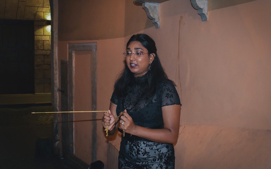 Tour guide leading a ghost walking tour in Rome at night.