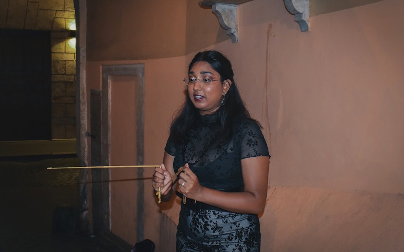 Tour guide leading a ghost walking tour in Rome at night.