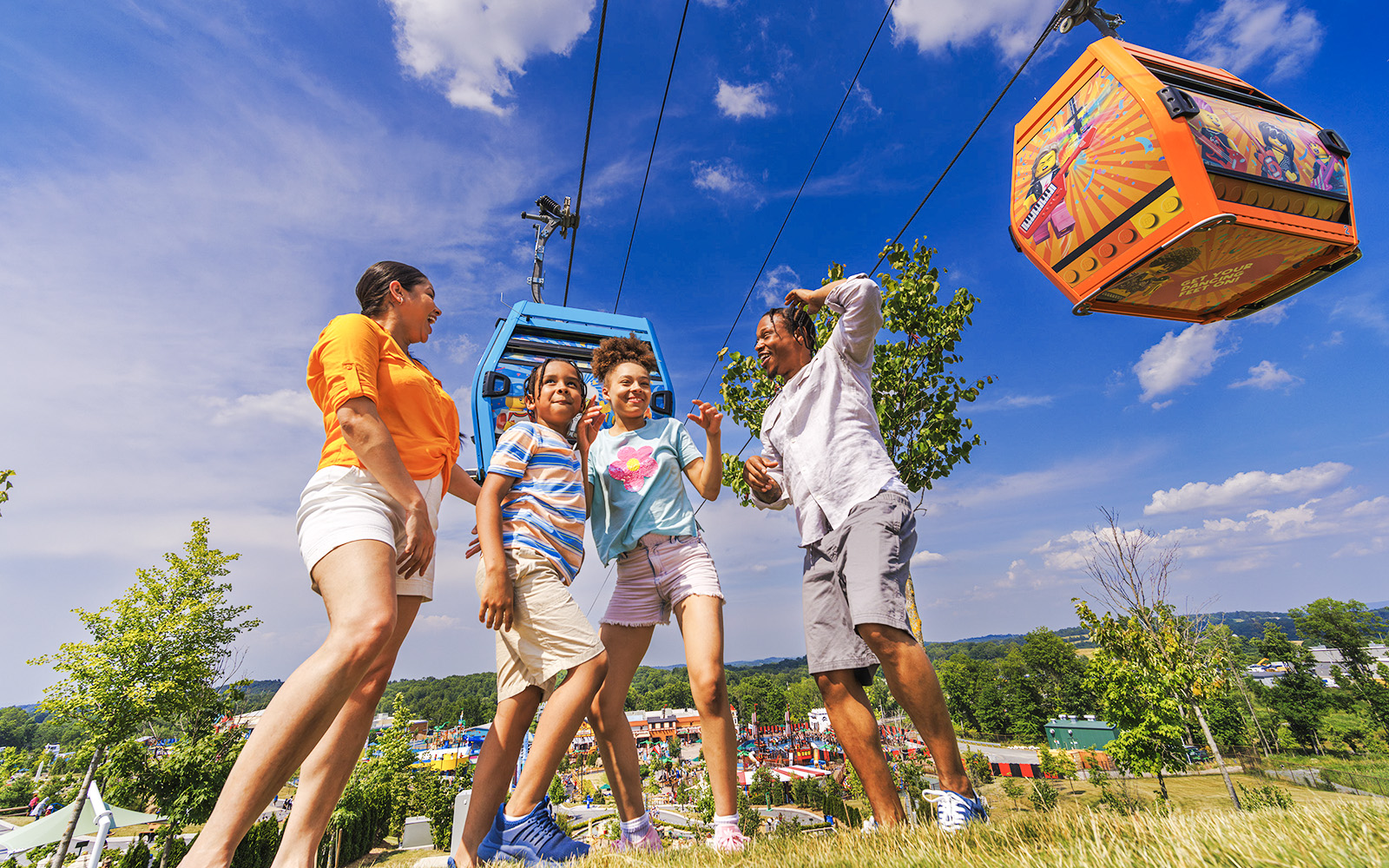 Guests enjoying a day at Legoland New York with cable cars overhead.