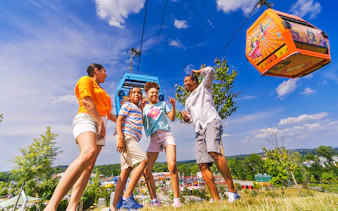 Guests enjoying a day at Legoland New York with cable cars overhead.