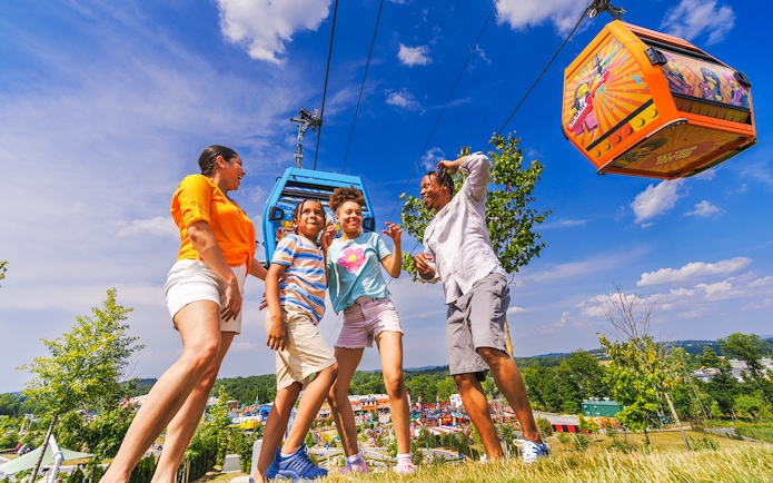 Guests enjoying a day at Legoland New York with cable cars overhead.