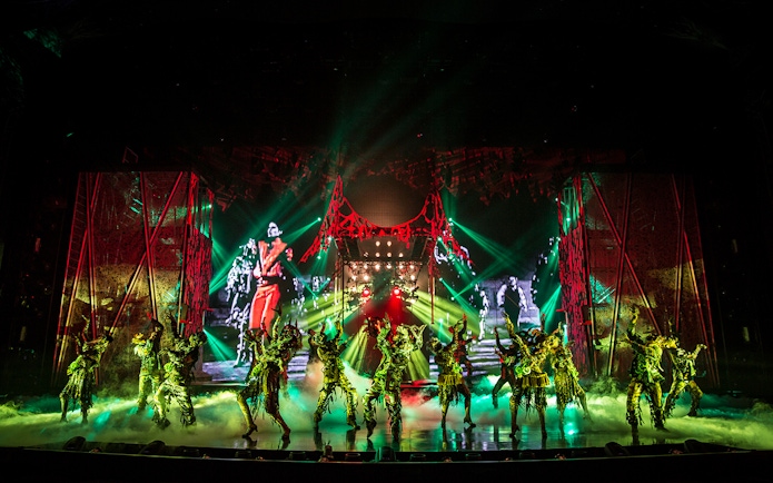 Performers on stage at Michael Jackson ONE show with vibrant lights and costumes.