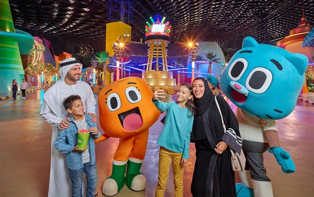 Family taking a selfie with cartoon characters at IMG World of Adventure, Dubai.