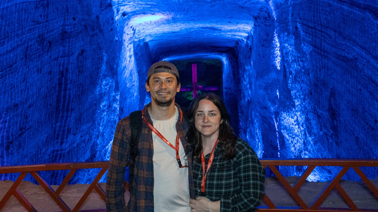 Tourists standing inside the illuminated Zipaquira Salt Cathedral in Colombia.
