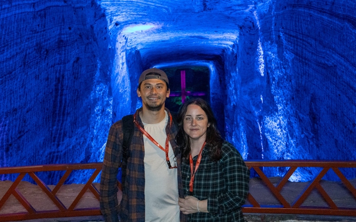 Tourists standing inside the illuminated Zipaquira Salt Cathedral in Colombia.