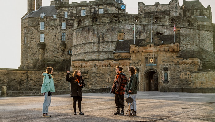 Tourists exploring Edinburgh's Royal Mile with historic buildings in view.