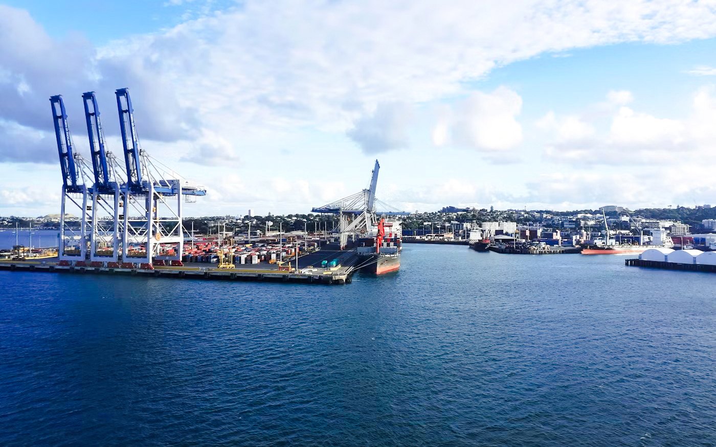 Harbour view with cranes and ships, ideal for a scenic wine and cheese cruise.