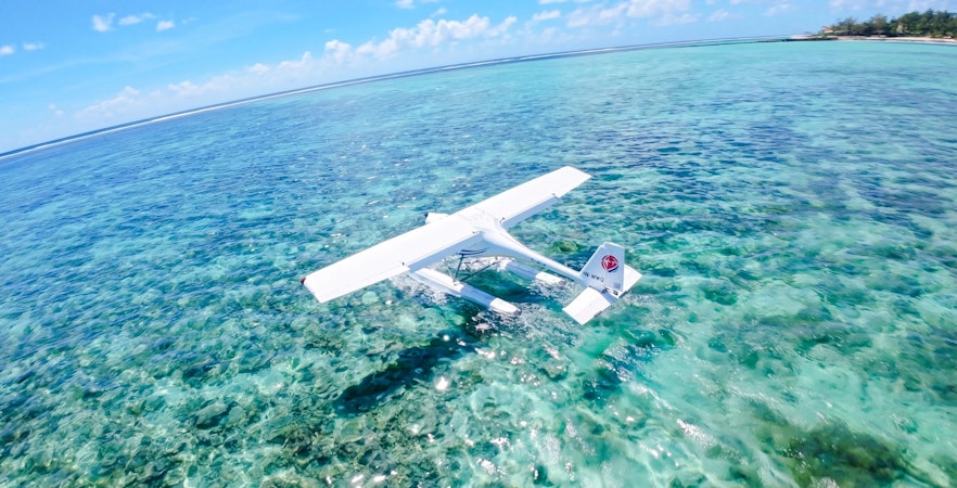 Seaplane flying over clear turquoise waters on the Eastern Underwater Waterfall route, Mauritius.